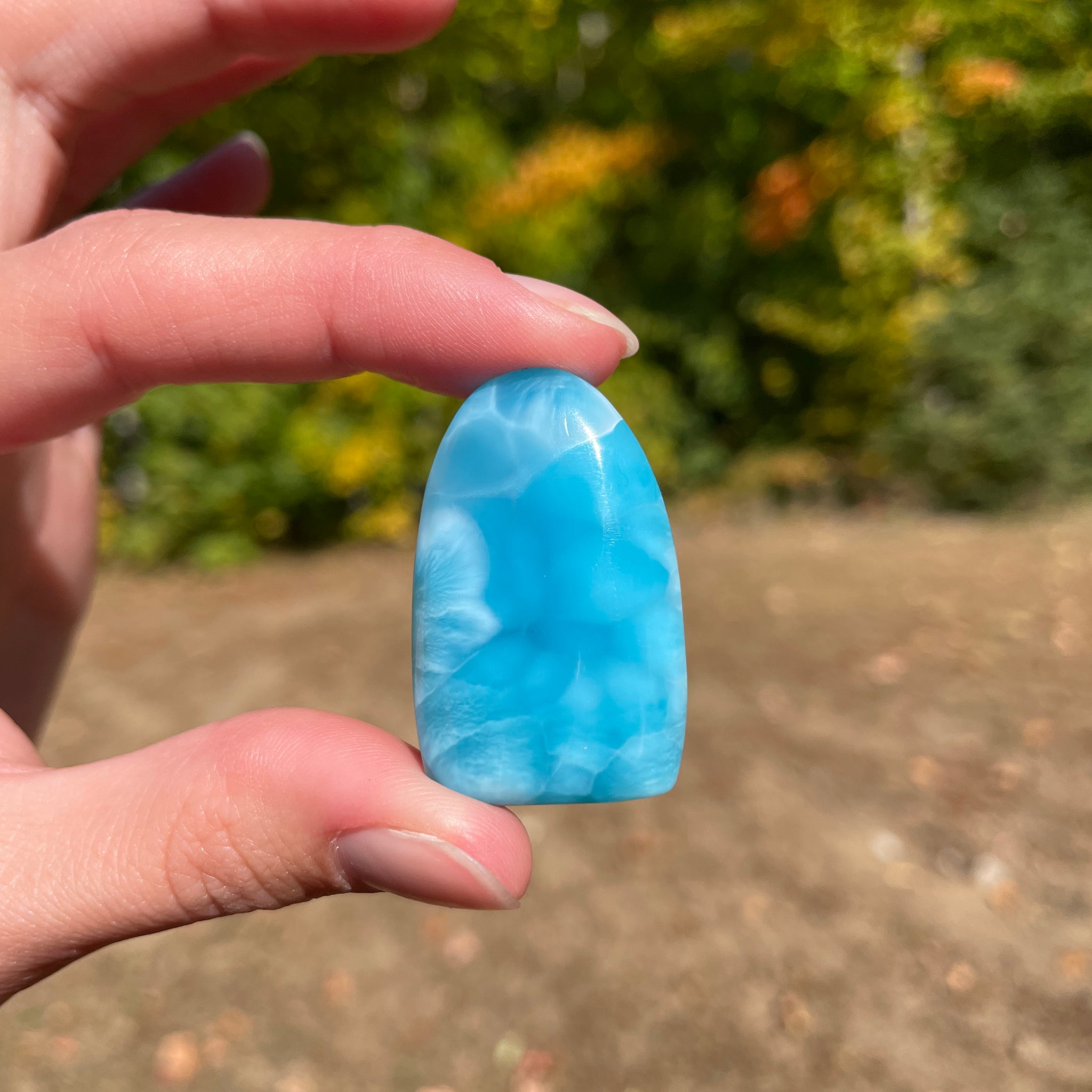 Super blue with soft white lines, oval top and flat bottom in shape with polished surface. It has effects on four of the seven Chakras